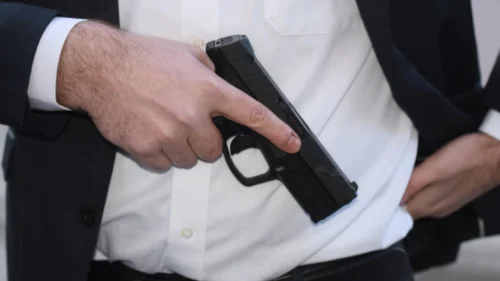 man holding an illegal firearm